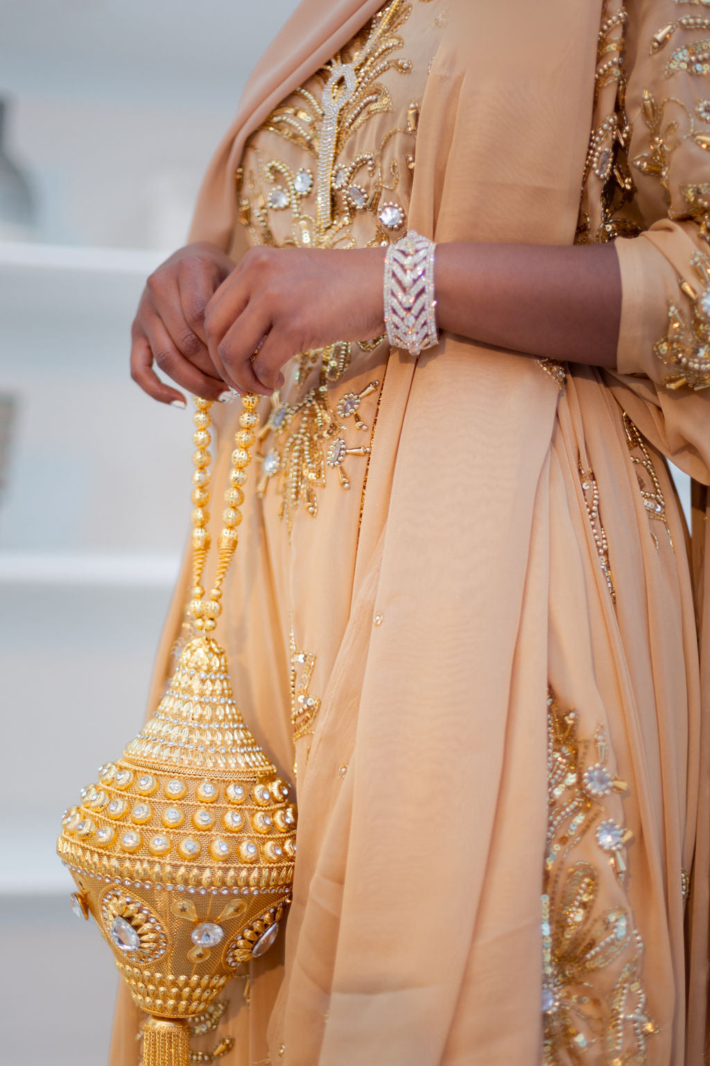 Woman wearing jewelry and champagne gold Somali bridal/wedding dirac.