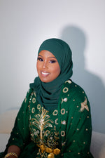 Load image into Gallery viewer, Woman wearing green Somali bridal/wedding dirac.
