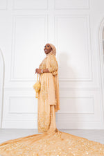 Load image into Gallery viewer, Woman wearing champagne gold Somali bridal/wedding dirac.
