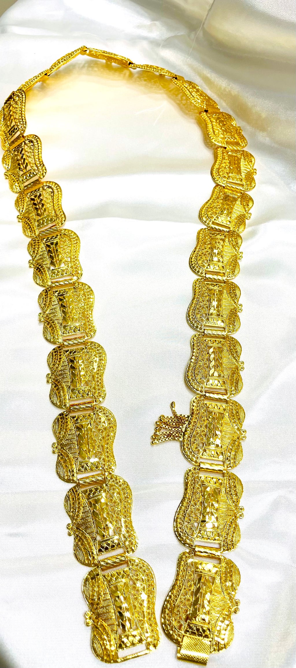 Gold belt for Somali bridal/wedding dirac laying atop a white surface.