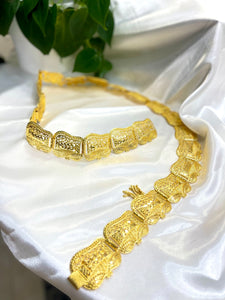 Gold belt for Somali bridal/wedding dirac laying atop a white surface.